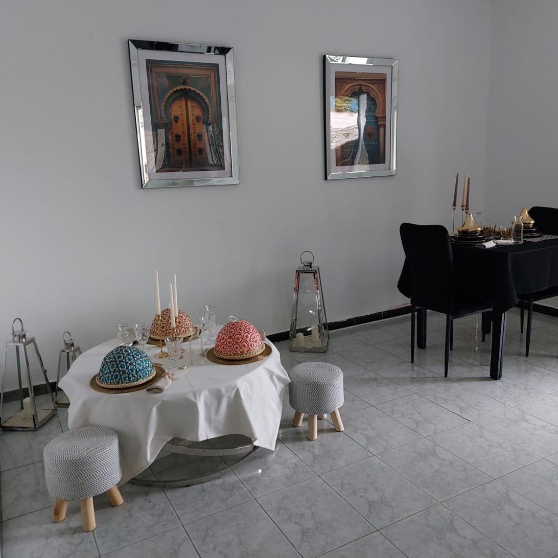 Salle à manger avec tableaux de portes marocaines encadrés et table ronde