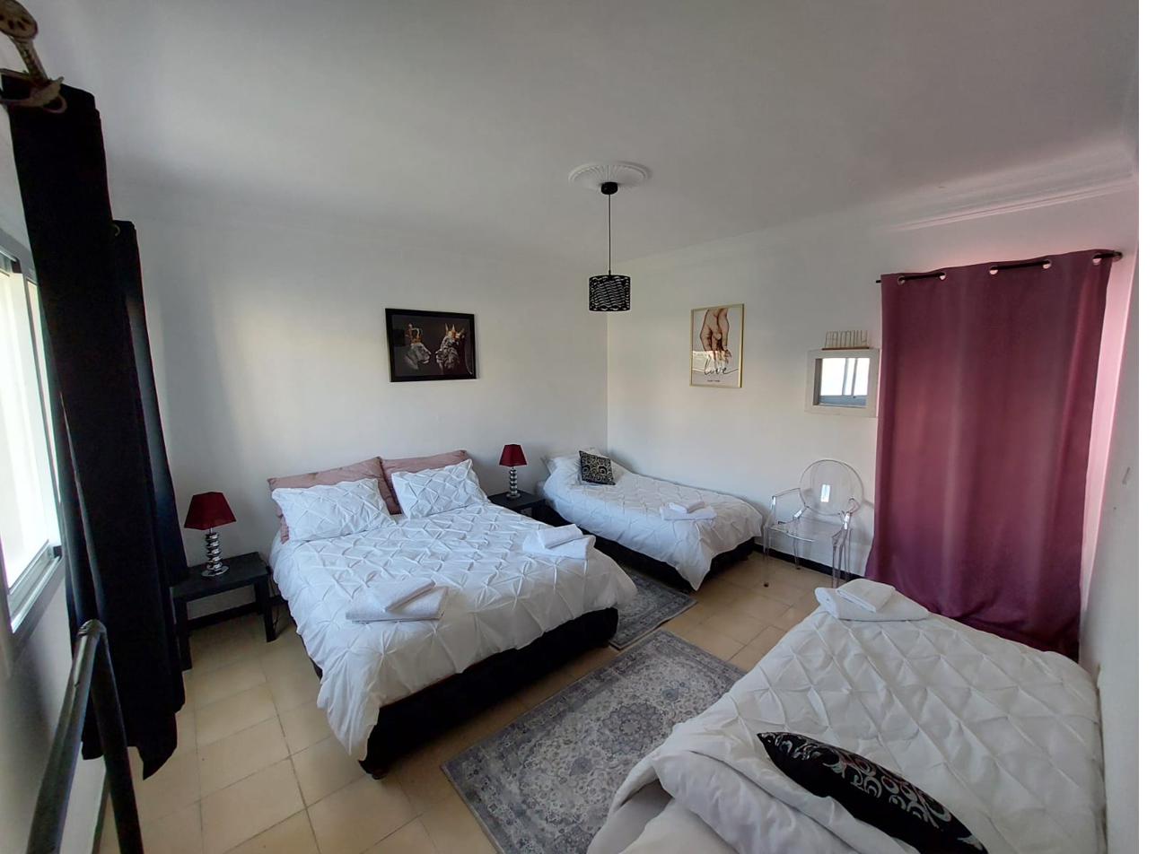 Chambre Malika : chambre familiale avec un grand lit et deux lits simples, rideaux pourpres