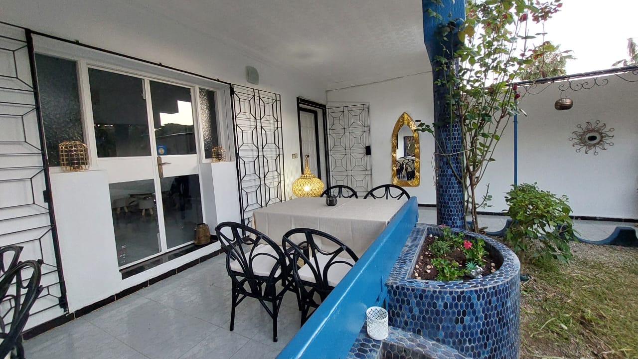 Terrasse de Dar Kamilia avec mosaïque bleu zellige, table dressée et lanternes en laiton